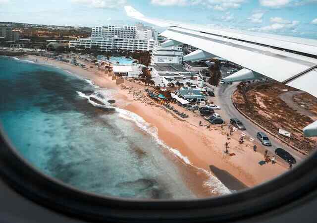 A person looking out of window on their flight to St. Maarten.